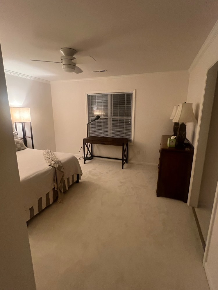Tastefully decorated guest bedroom with desk and dresser