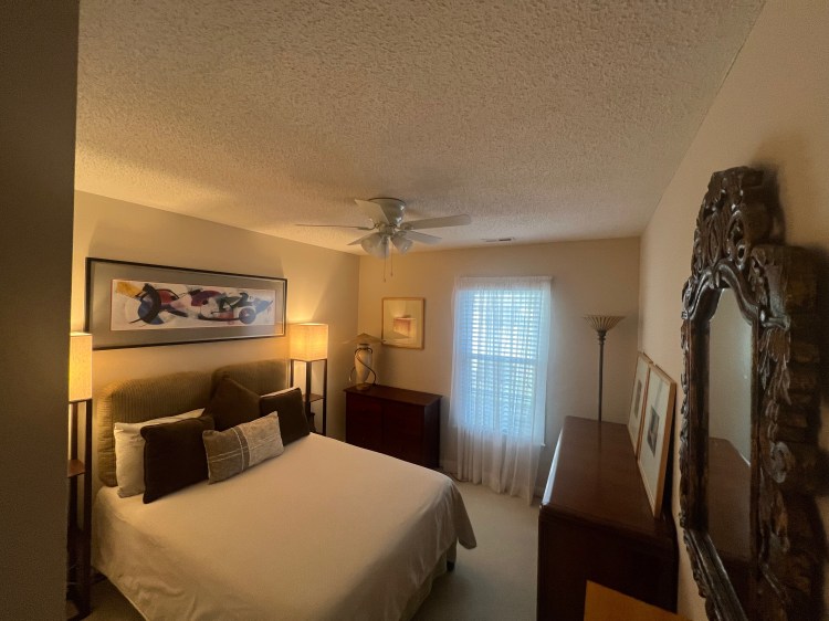 Bedroom with dressers, lamps and art on the walls.