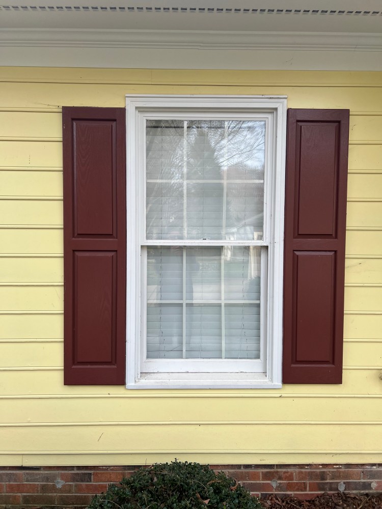 Window with shutters on a yellow house